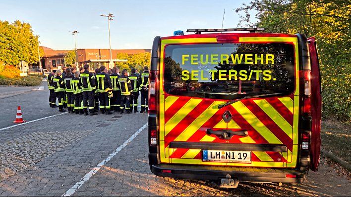 Lagebesprechung der Feuerwehr Selters vor dem Gebäudekomplex der Zeugen Jehovas. Foto: Peter Ehrlich