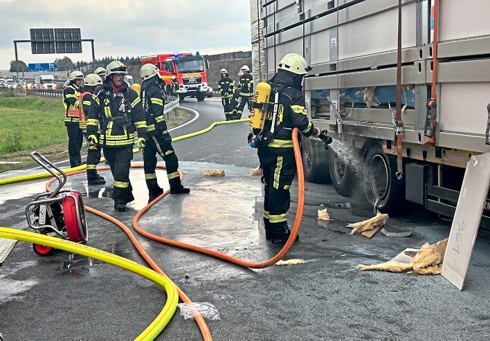 Einsatzkräfte der Feuerwehr löschen den Brand an einem Auflieger eines Sattelschleppers an der Einfahrt zur Autobahnraststätte Limburg-Ost. Foto: Klaus-Dieter Häring