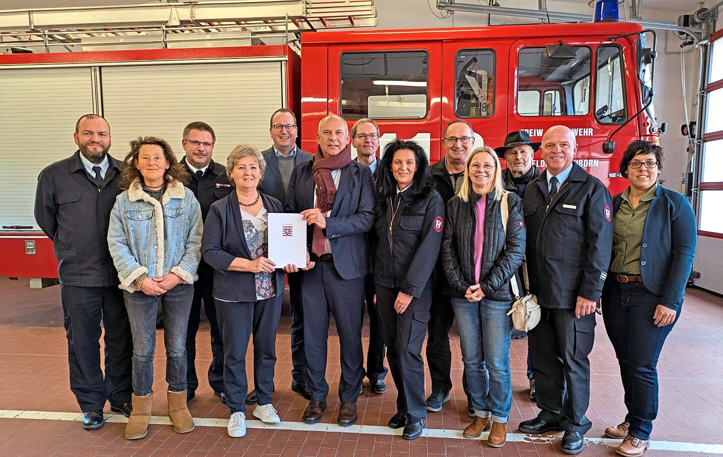 Bürgermeisterin Silvia Scheu Menzer (Vierte von links) mit dem Landtagsabgeordneten Christian Wendel (Fünfter von links), Innenminister Roman Poseck (Sechster von links) bei der Förderbescheidübergabe in Hünfelden mit Vertretern aus Politik, Feuerwehr und Verwaltung. Foto: Gemeinde Hünfelden