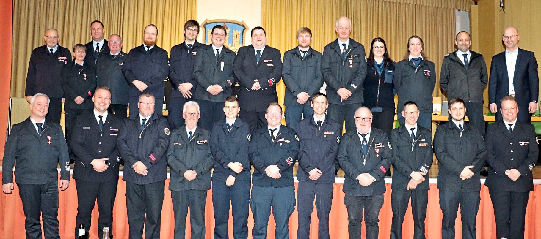 Gemeindebrandinspektor Christoph Eule (vorne, links) und Bürgermeister Daniel Melchert (hinten, rechts) können für viele Aktive Ernennungen und Beförderungen aussprechen und Anerkennungsprämien für langjährige Dienstzeiten überreichen. Fotos: Dorothee Henche