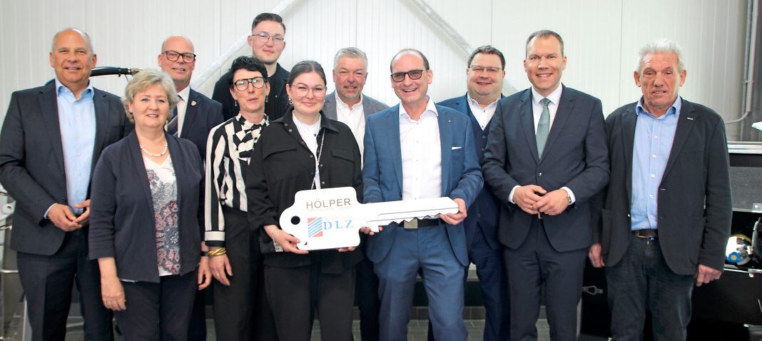 Architekt Oliver Hamm (vorne rechts) übergibt den symbolischen Schlüssel für das Feuerwehr-Dienstleistungszentrum an Bauherrin Luna Hölper. Von links mit im Bild sind der hessische Innenminister Roman Poseck (CDU), Bürgermeisterin Silvia Scheu-Menzer (Hünfelden, parteilos), Bürgermeister Frank Groos (Brechen, parteilos), Nicole, Maximilian und Mathias Hölper, Bürgermeister Götz Esser (Weilrod, FWG), Bürgermeister Daniel Rühl (Bad Camberg, CDU) und der Erste Beigeordnete der Gemeinde Selters Georg Herz (UWE). Fotos: Petra Hackert