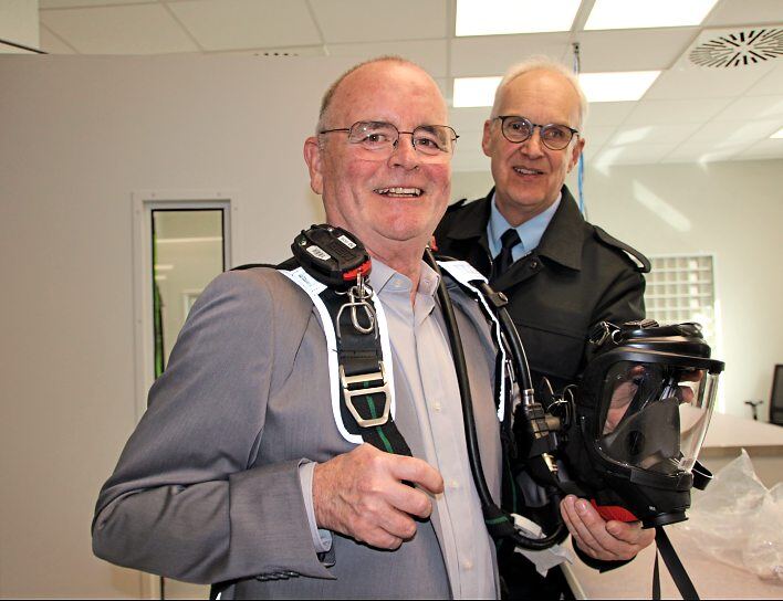 Helmut Thies warjahrzehntelang Stadtbrandinspektor in Bad Camberg. Bei der Einweihung des Feuerwehr-Dienstleistungszentrums legt er noch einmal Atemschutz an. Holger Sarg, seit 34 Jahren ehrenamtlicher Gerätewart bei der Feuerwehr Weilrod, hilft. Fotos: Petra Hackert